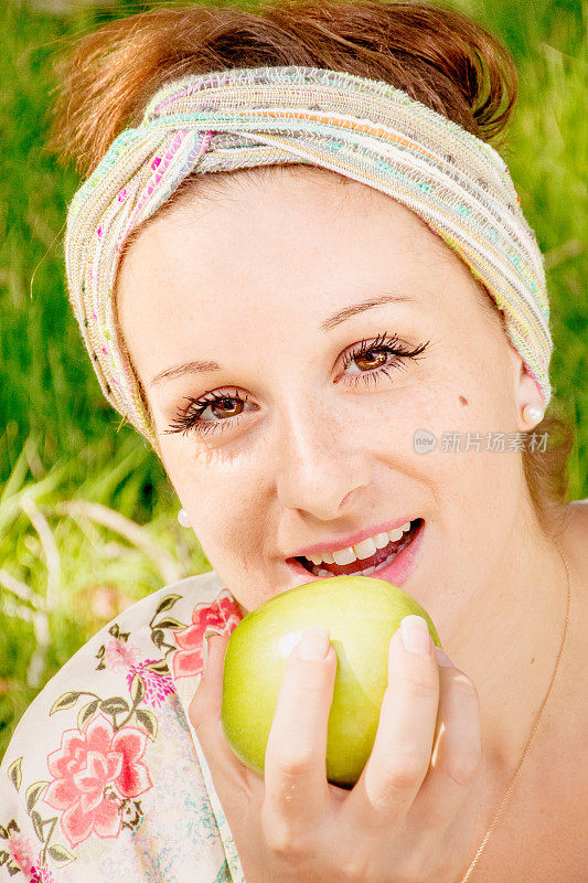年轻女子在户外吃苹果