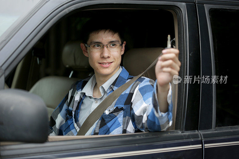 快乐的年轻男性司机看着车钥匙