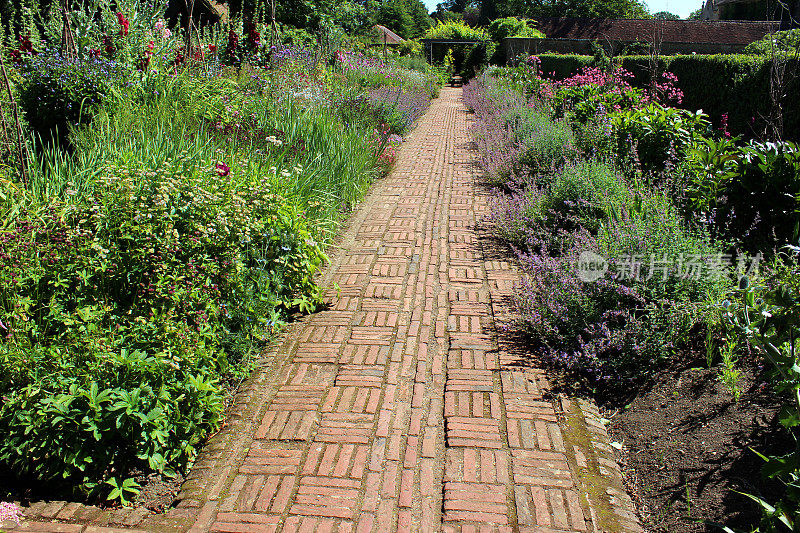 红砖砌成的小径，两旁点缀着花草，村舍花园