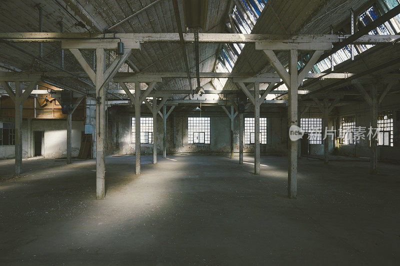 旧的，废弃的工厂大厅，阳光透过窗户照进来