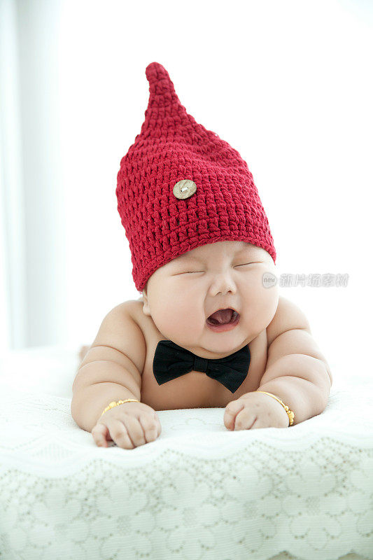 头上戴着一顶红帽子的超重婴儿