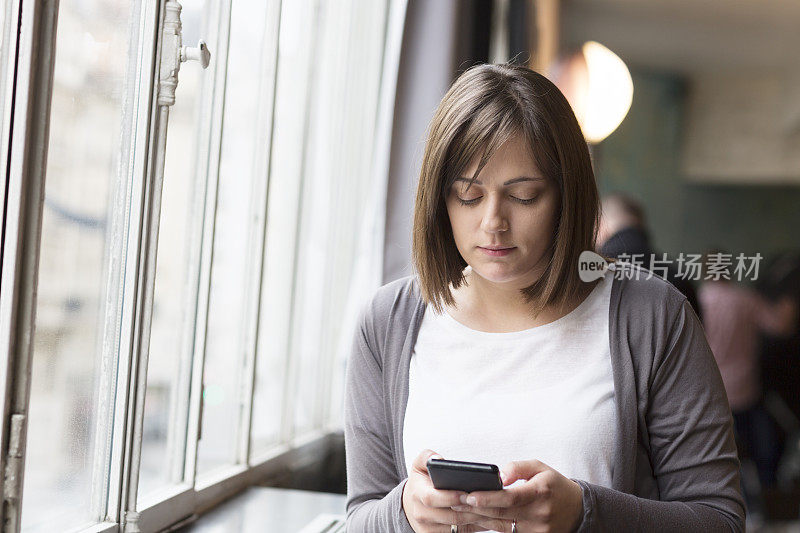 一个年轻女子用手机发短信的照片