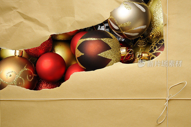 撕破的棕色包装纸包裹着圣诞球