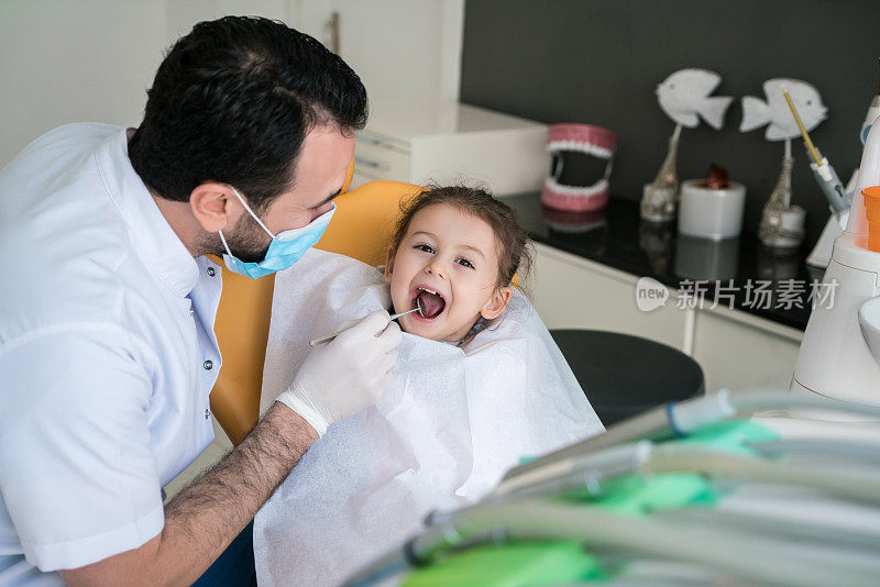 快乐的蹒跚学步的小女孩正在牙医诊所检查牙齿。