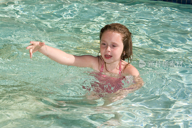 小女孩在游泳池里游泳