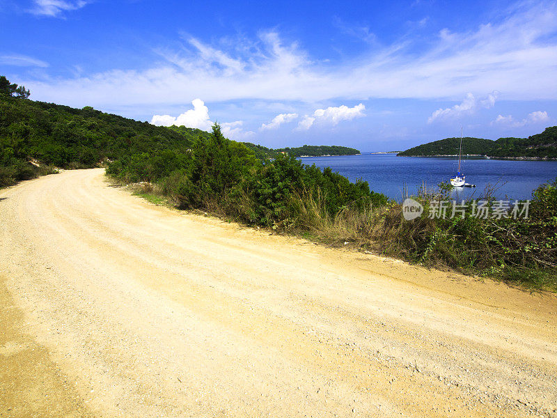 洛克瓦湾周围的道路，蓝色的海水和一艘船可见