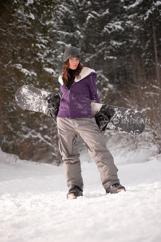 年轻漂亮的女人享受着单板滑雪的日子