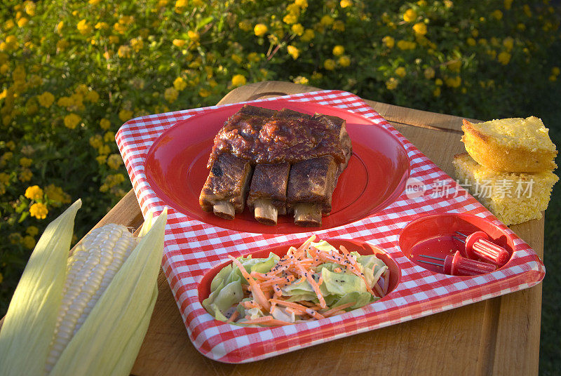 烧烤排骨、美式排骨野餐桌;玉米面包和卷心菜食品