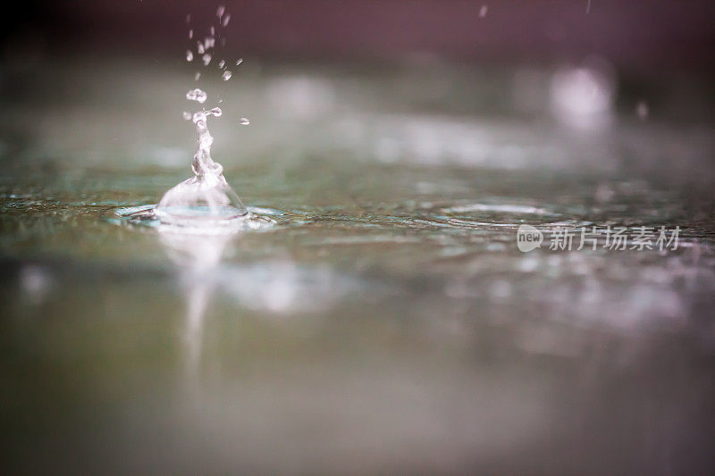 暴雨期间雨滴撞击水坑的特写。