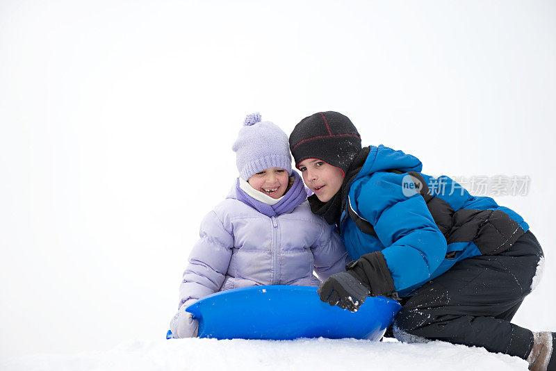 哥哥和妹妹在雪地里拉雪橇