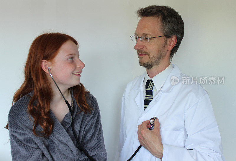 小女孩在医院里用听诊器听医生的心跳