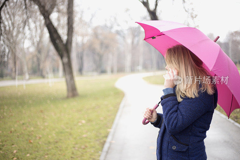 年轻女子与手机在雨天