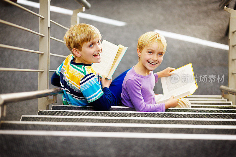 快乐的弟弟和妹妹在台阶上读书
