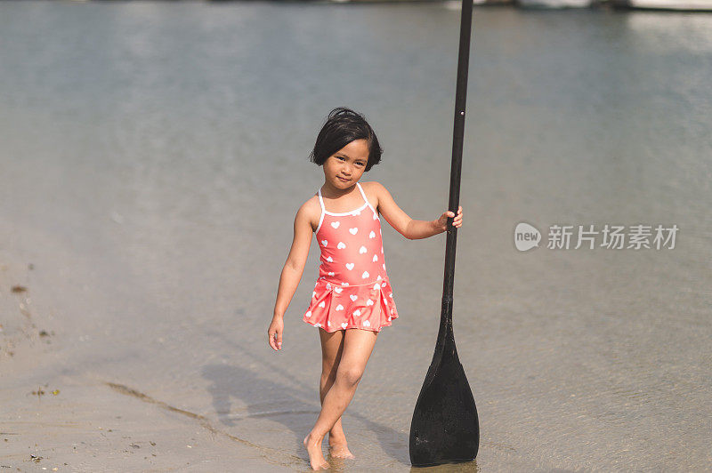 可爱的年轻菲律宾女孩与船桨在河边摆姿势