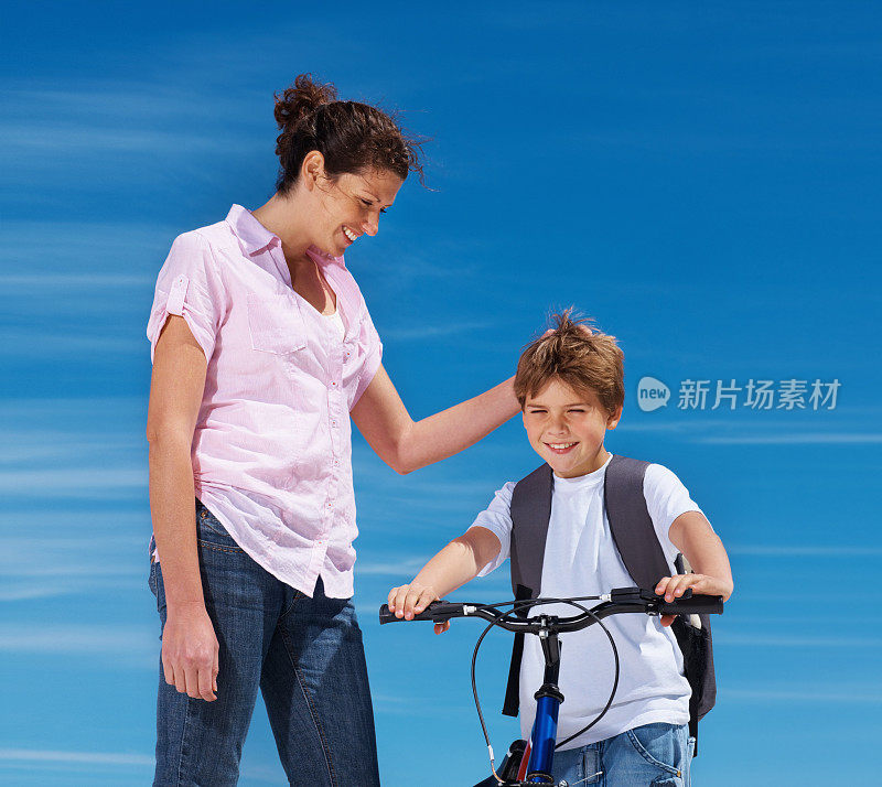 母亲帮儿子骑自行车