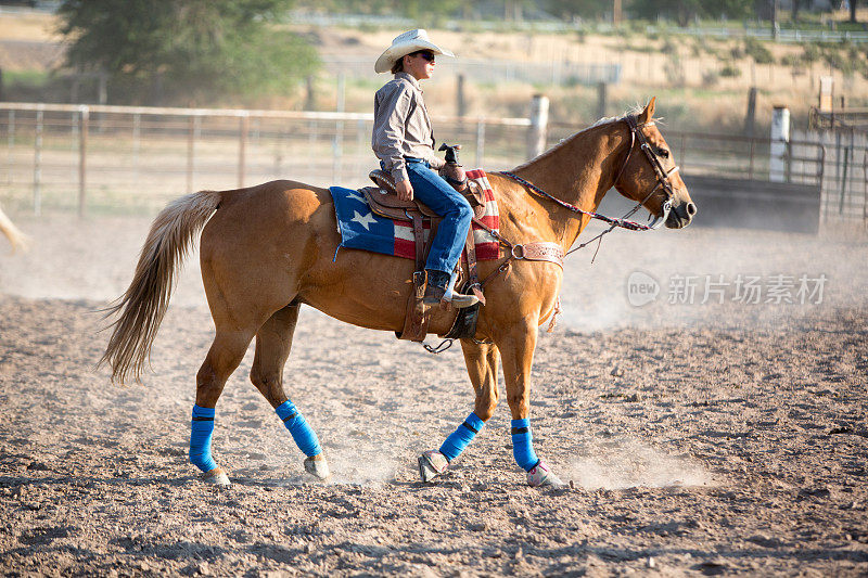 牛仔竞技会上骑在马背上的年轻牛仔