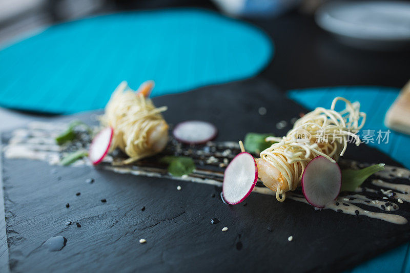 黑盘酱面虎虾。亚洲食物的背景。饮食的概念。餐厅的地方与木桌。
