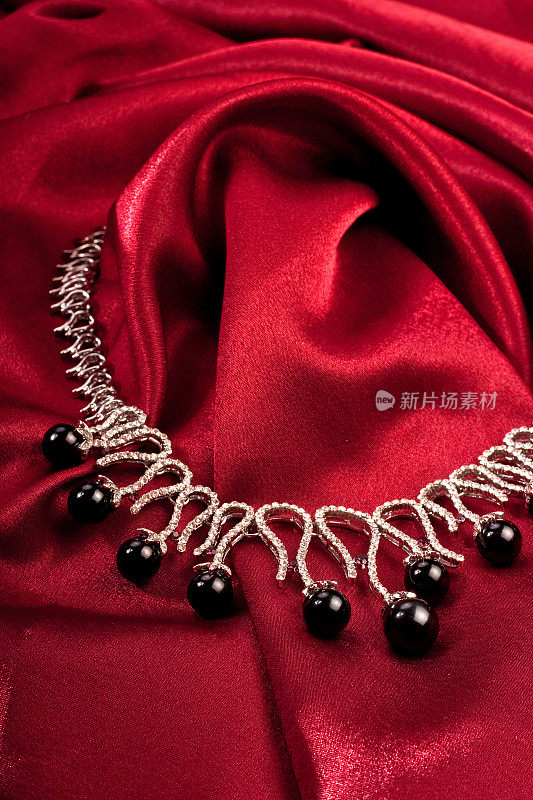 红色纺织品上的黑珍珠