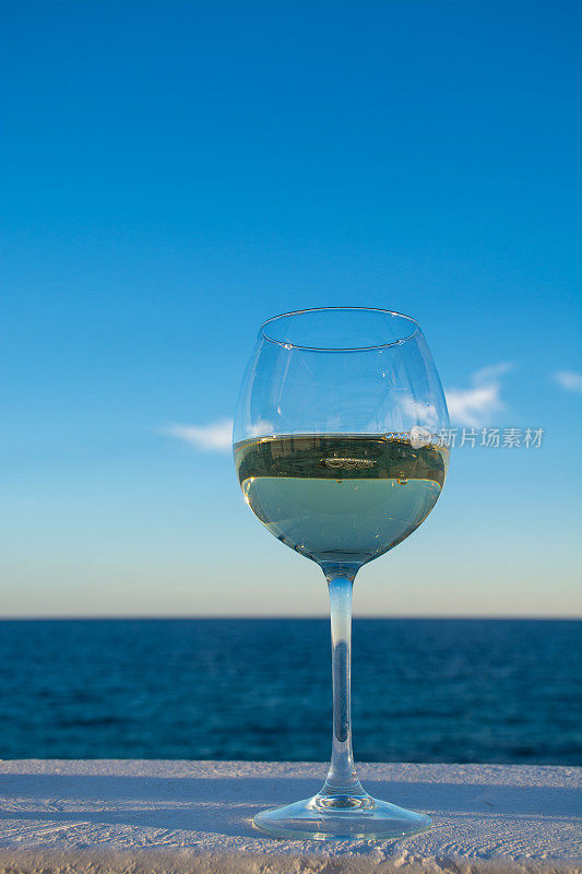 一杯冷白葡萄酒提供的室外阳台与海景
