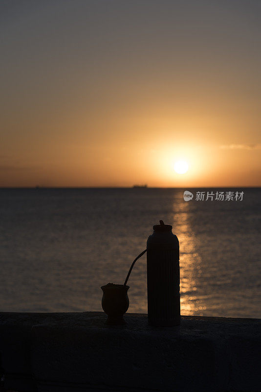 海滩上的日落，伴着家电和葫芦的剪影。