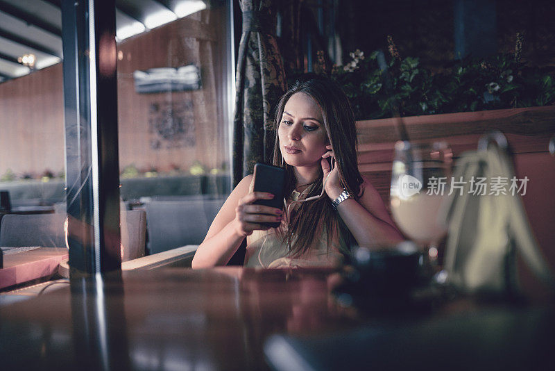 可爱女性在餐厅用智能手机建立视频会议