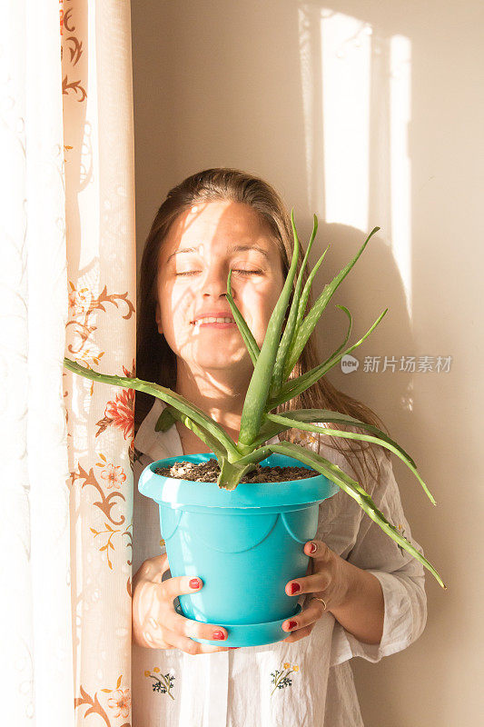 拿着芦荟植物的女人