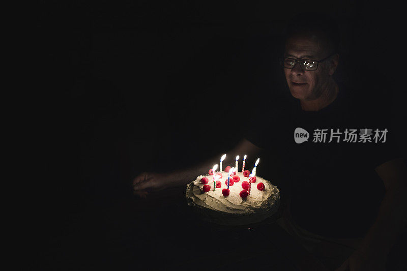 一个吹灭生日蛋糕上蜡烛的男人