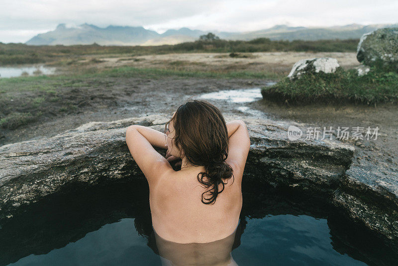在冰岛的热水池里游泳的女人