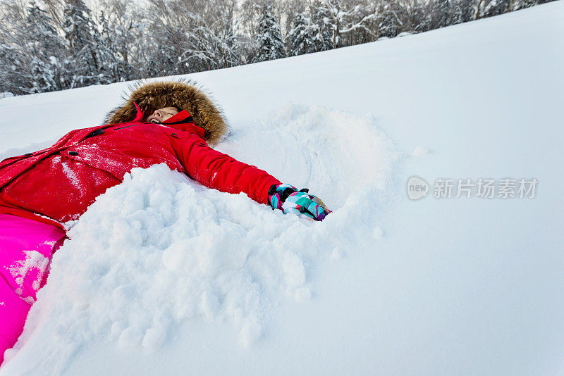 女人躺在地上，做雪天使