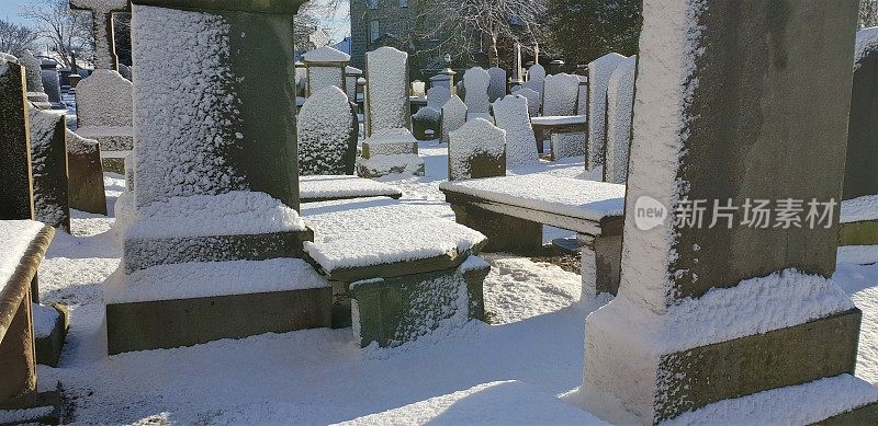 白雪覆盖的墓地里的坟墓、墓碑和墓碑