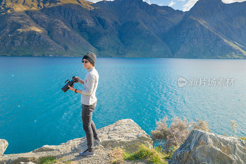 年轻的旅行者在库克法默斯山的目的地在新西兰拍照