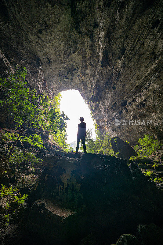 越南恒田洞，一名男性洞穴探险者用头灯仰视的剪影