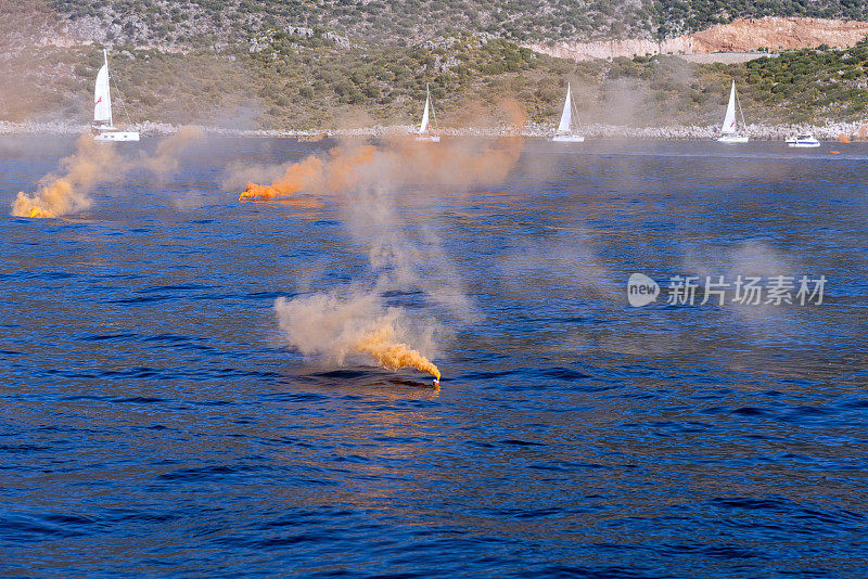 橙色烟雾弹与帆船。遇险信号