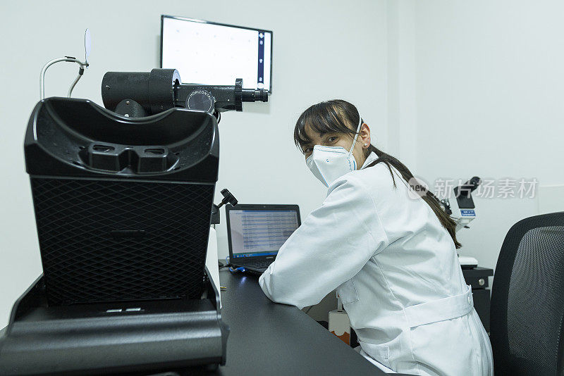拉丁女医生专业分析医学样本通过最先进的显微镜