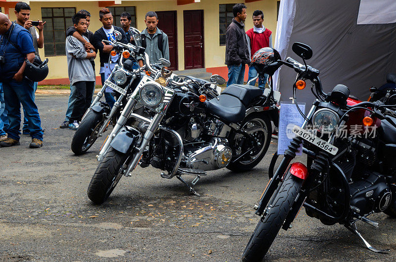 参观者、骑手和哈雷戴维森摩托车爱好者在一个展览会上欣赏哈雷戴维森摩托车的展示。