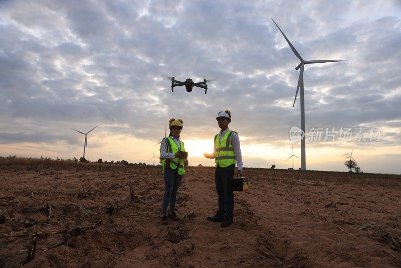 伙伴维护和设计工程师在风力发电机领域用无人机调查风力发电机，绿色能源，可再生能源的概念