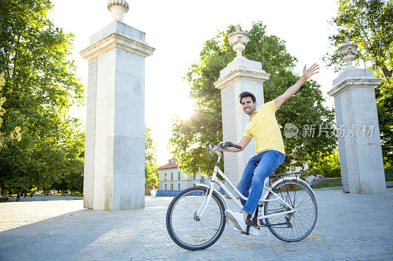 快乐的男人微笑着享受在户外骑自行车。