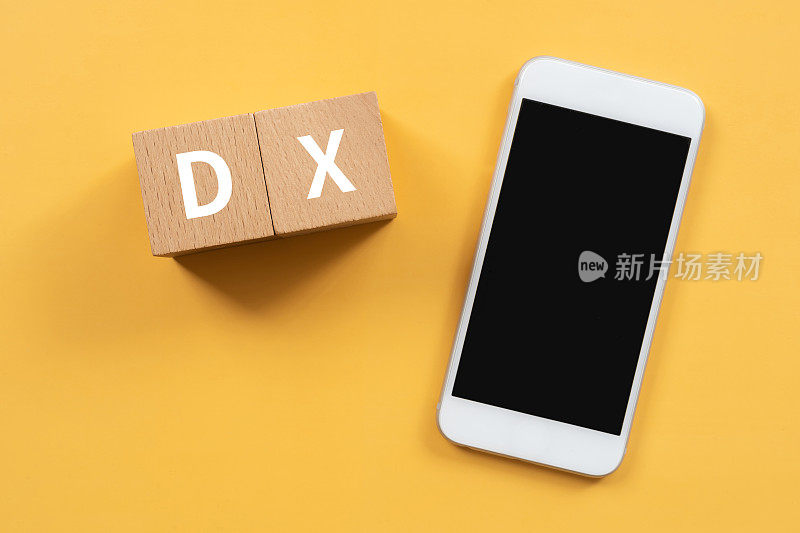 木制积木与“DX”文本的概念和一个智能手机。