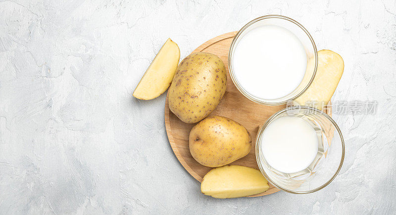 玻璃素食土豆奶和生土豆。替代植物奶。超级食品的概念。健康,干净的吃。素食或无麸质饮食。俯视图