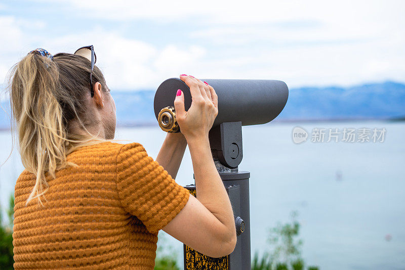 年轻的女性通过塔观看。