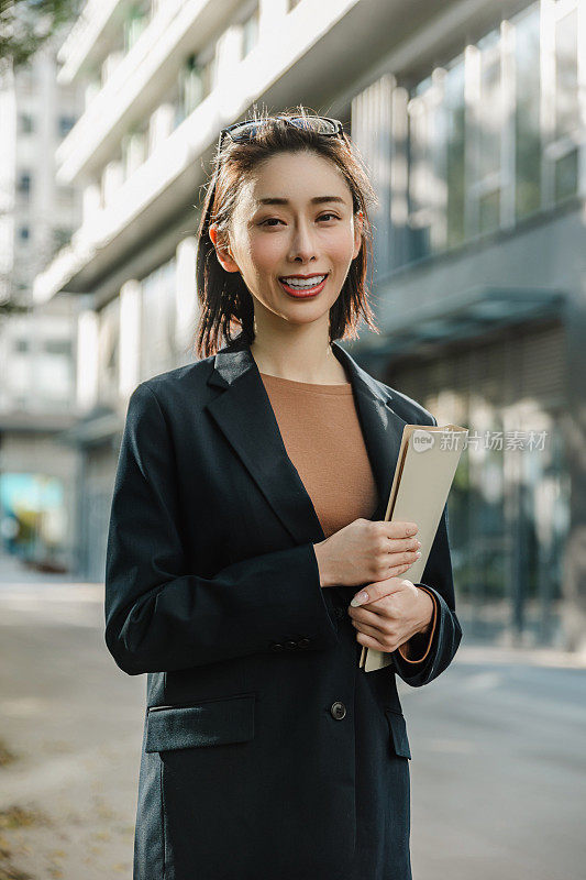 成功的女经理站在城市的大街上。