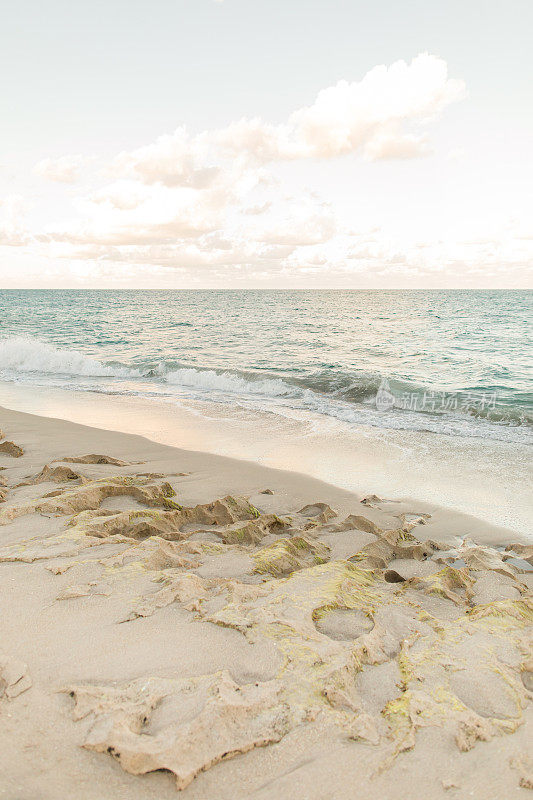 2023年1月，佛罗里达州辛格岛日落时，海浪沿着空旷的岩石海滩海岸线飞溅