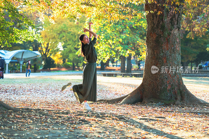 美丽的女子在秋天的森林里跳舞