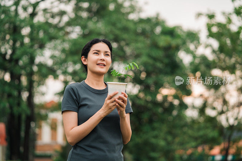 在大自然中抱着植物的女人