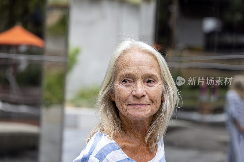 幸福的老年妇女在城市的肖像，正面视图，背景与复制空间