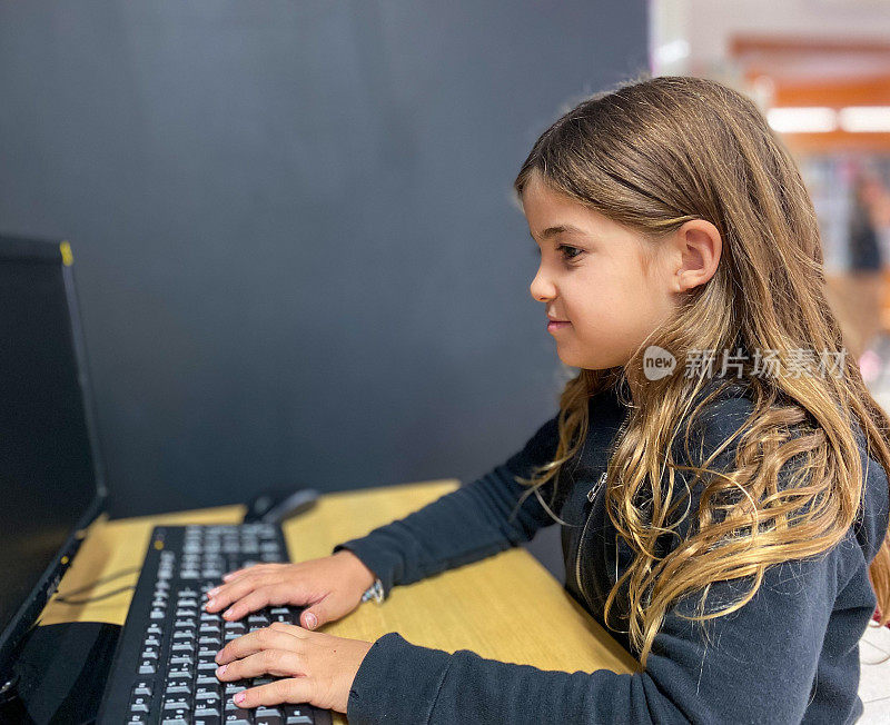 女孩微笑着坐在电脑前上课
