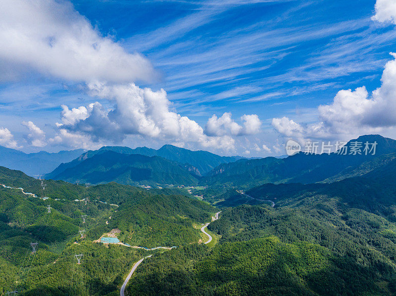 在蓝天白云的群山中俯瞰蜿蜒的道路