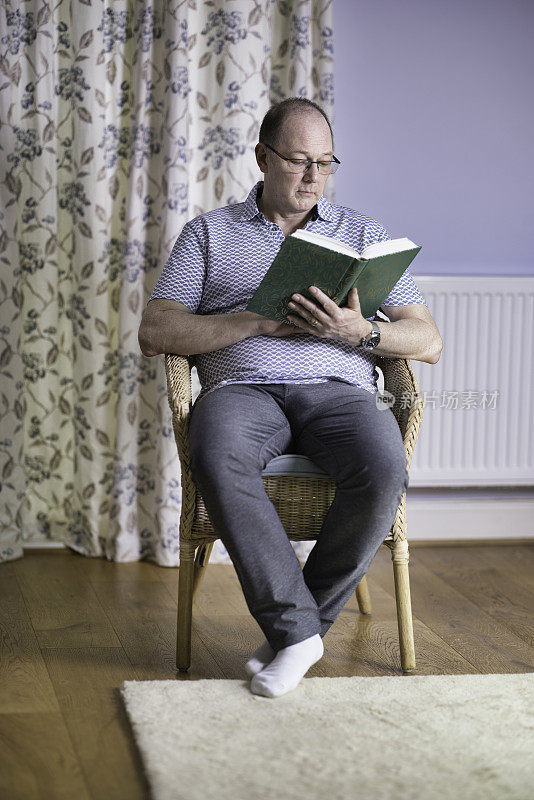 60岁老人在家看书