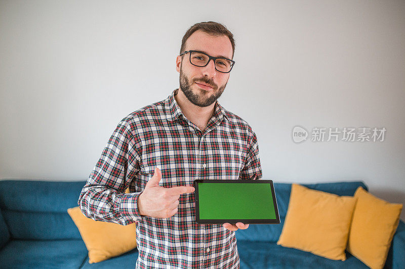 一名男子手持绿屏数码平板电脑的画像