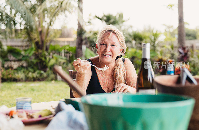 夏天，一家人在户外露台上一起吃饭，主要是老年成年女性